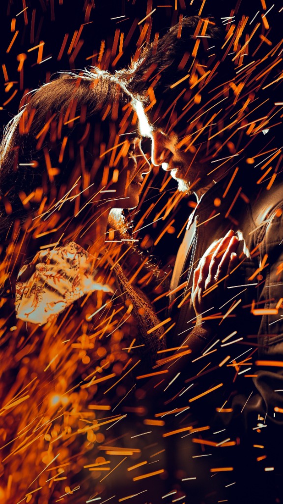 Candid couple portrait with fire sparks during night pre-wedding shoot